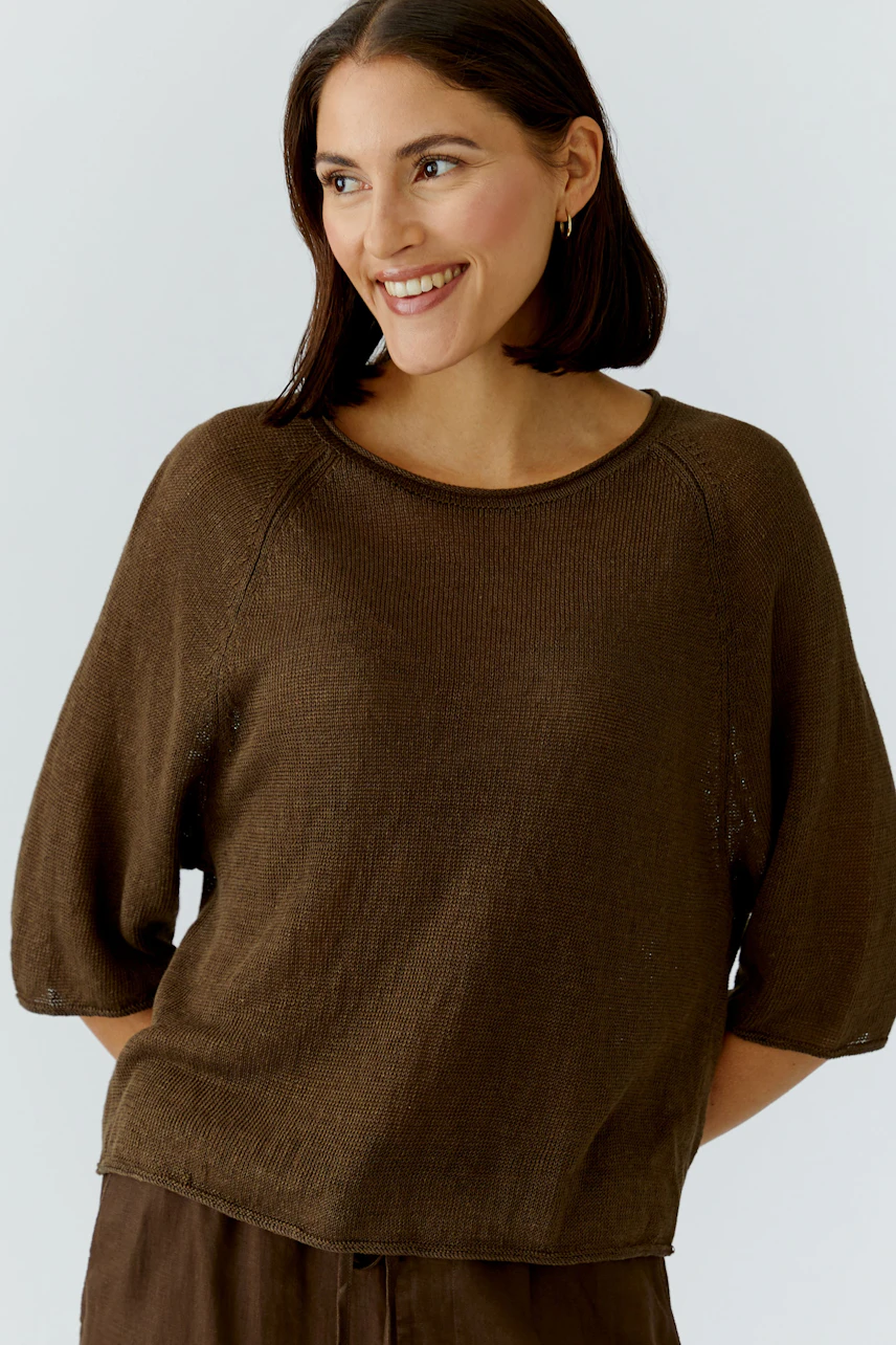 Lässiger Damen-Pullover: Frau im braunen Pullover mit Dreiviertelärmeln lächelt entspannt.