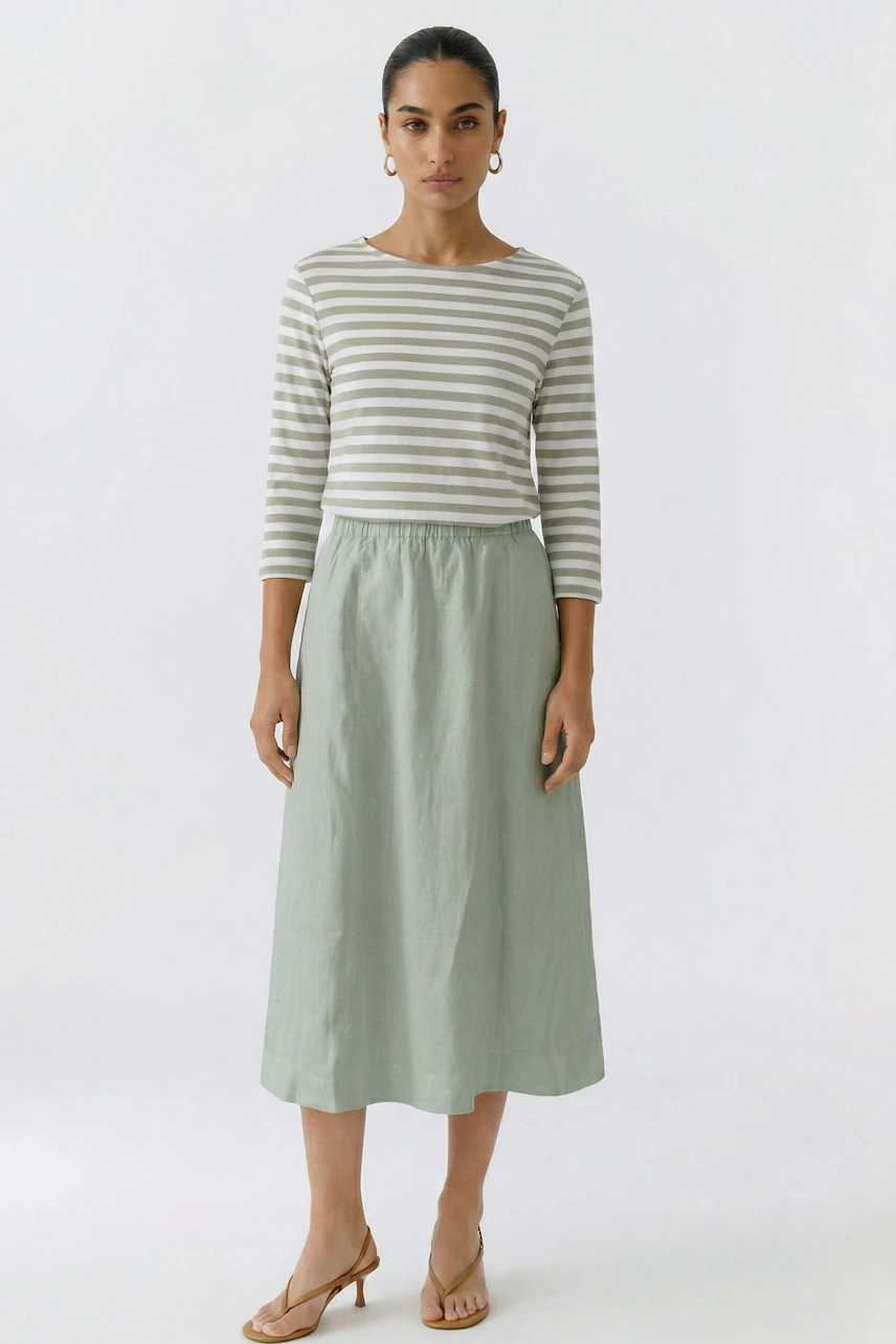 A-line skirt: Woman in a light green A-line skirt and matching top, standing confidently.