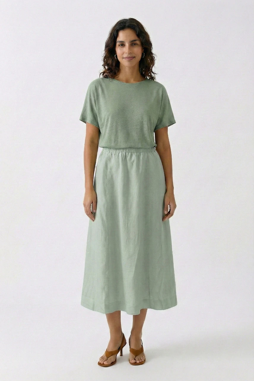 A-Linien-Rock: Frau in grünem Rock und passendem Oberteil, lässig und stilvoll.