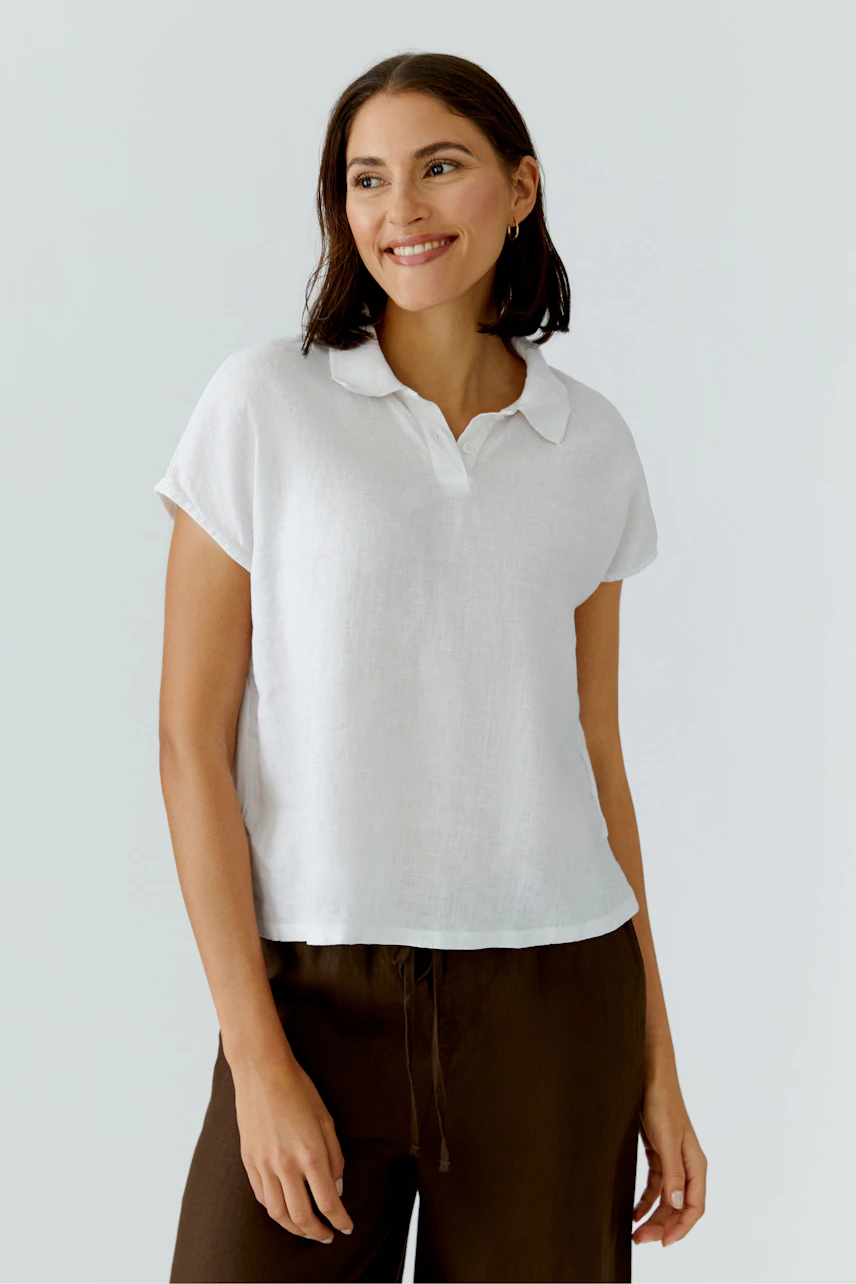 Casual women's blouse: Woman in a white blouse with short sleeves and a relaxed fit, smiling confidently.