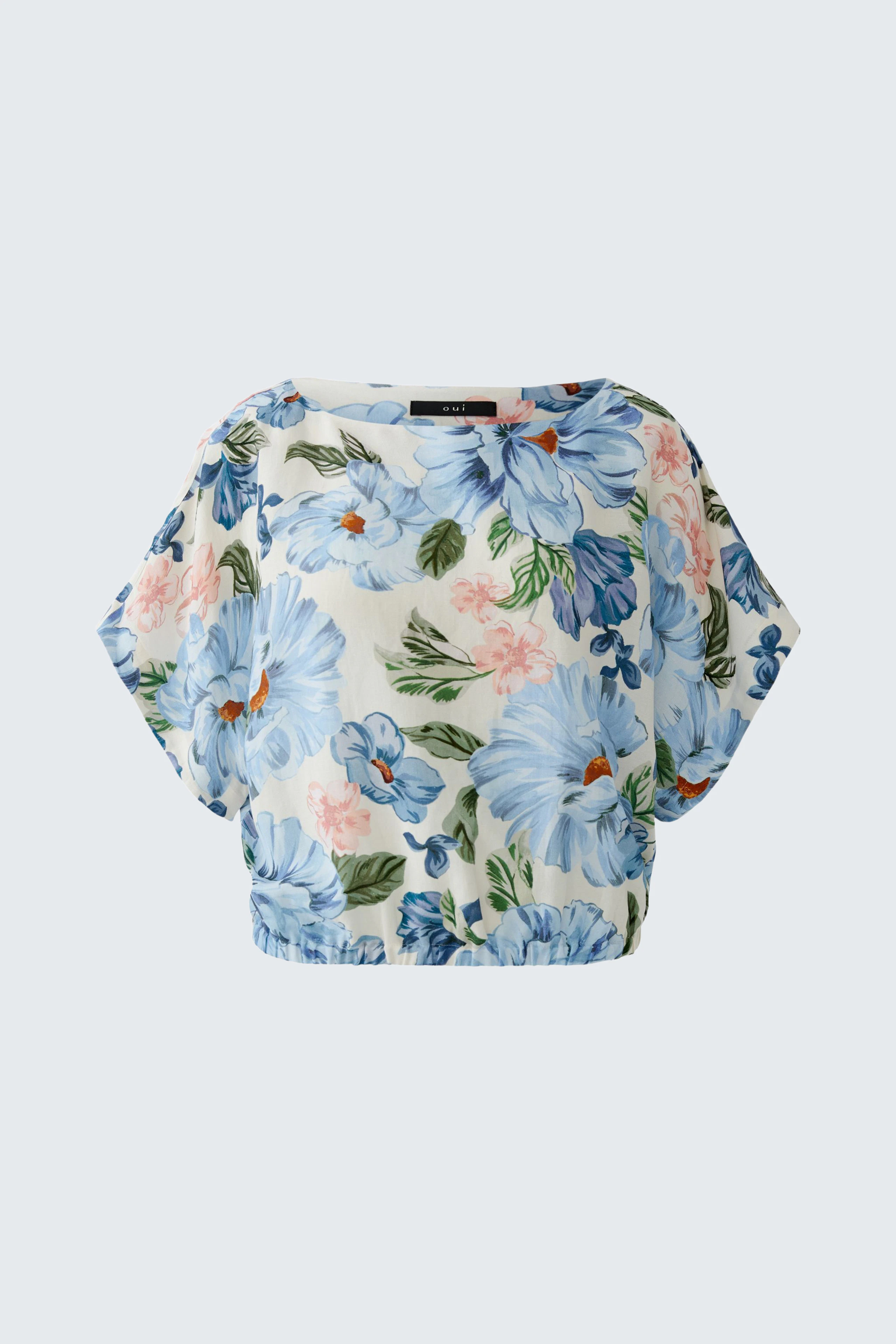 Floral blouse: A woman in a light blue floral blouse with a relaxed fit, perfect for casual outings.