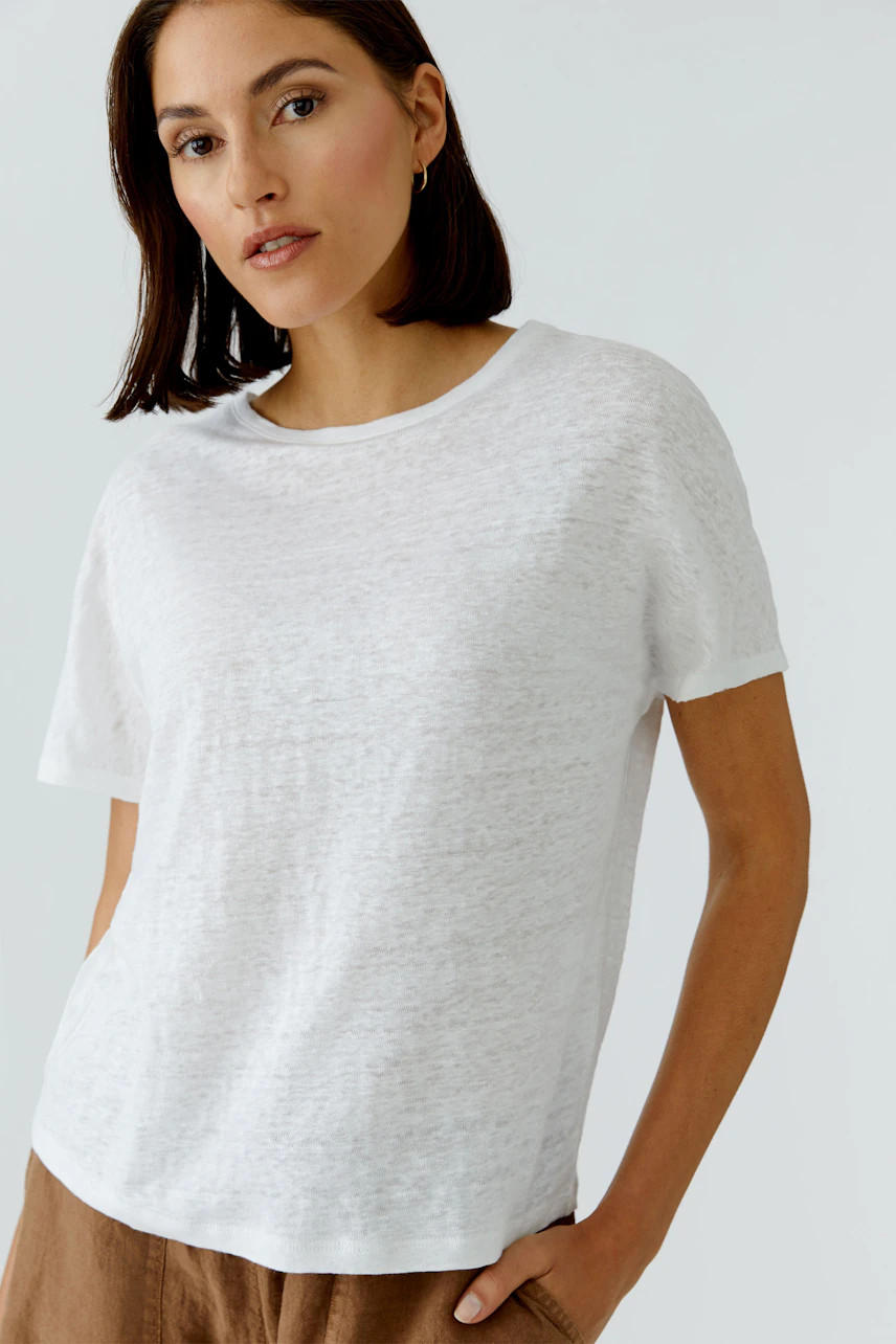 Casual women's T-shirt: Woman in a white T-shirt with short sleeves and relaxed fit, looking confidently.