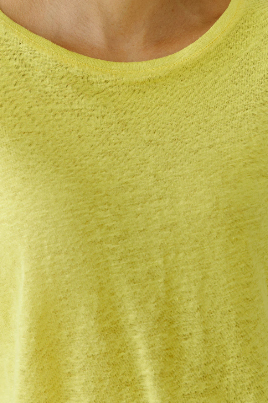Bright yellow T-shirt: Close-up of a woman's casual T-shirt with a soft texture and round neckline.