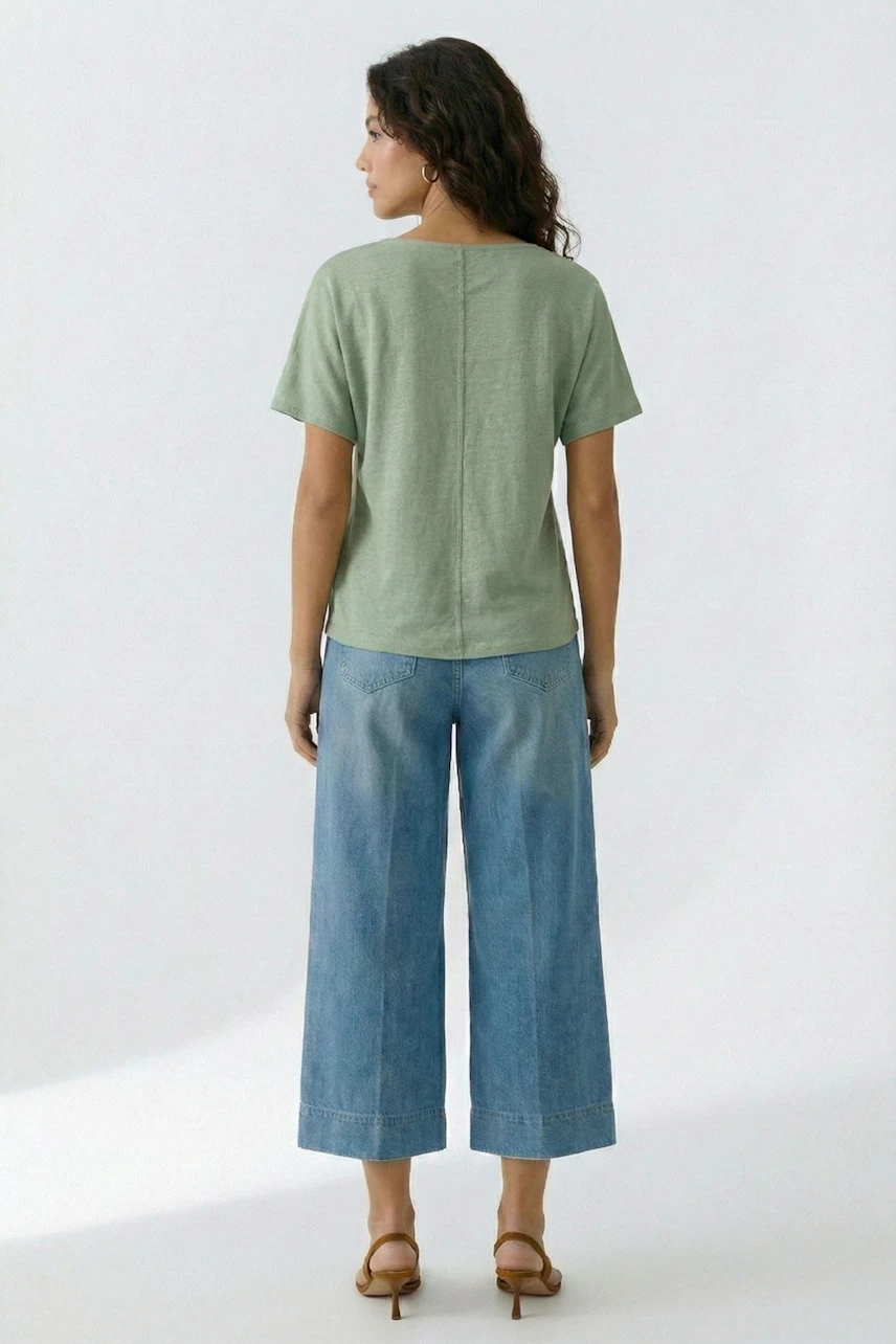 Lässiges Damen-T-Shirt: Frau im grünen T-Shirt und blauen Jeans, von hinten gesehen.