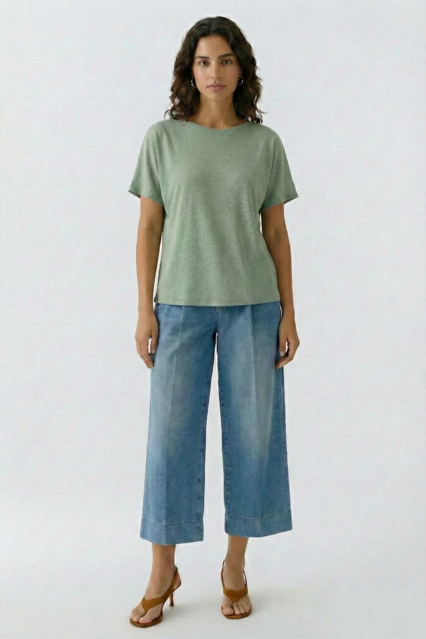 Lässiges Damen-T-Shirt: Frau im grünen T-Shirt und blauer Jeans, entspannt und modern.