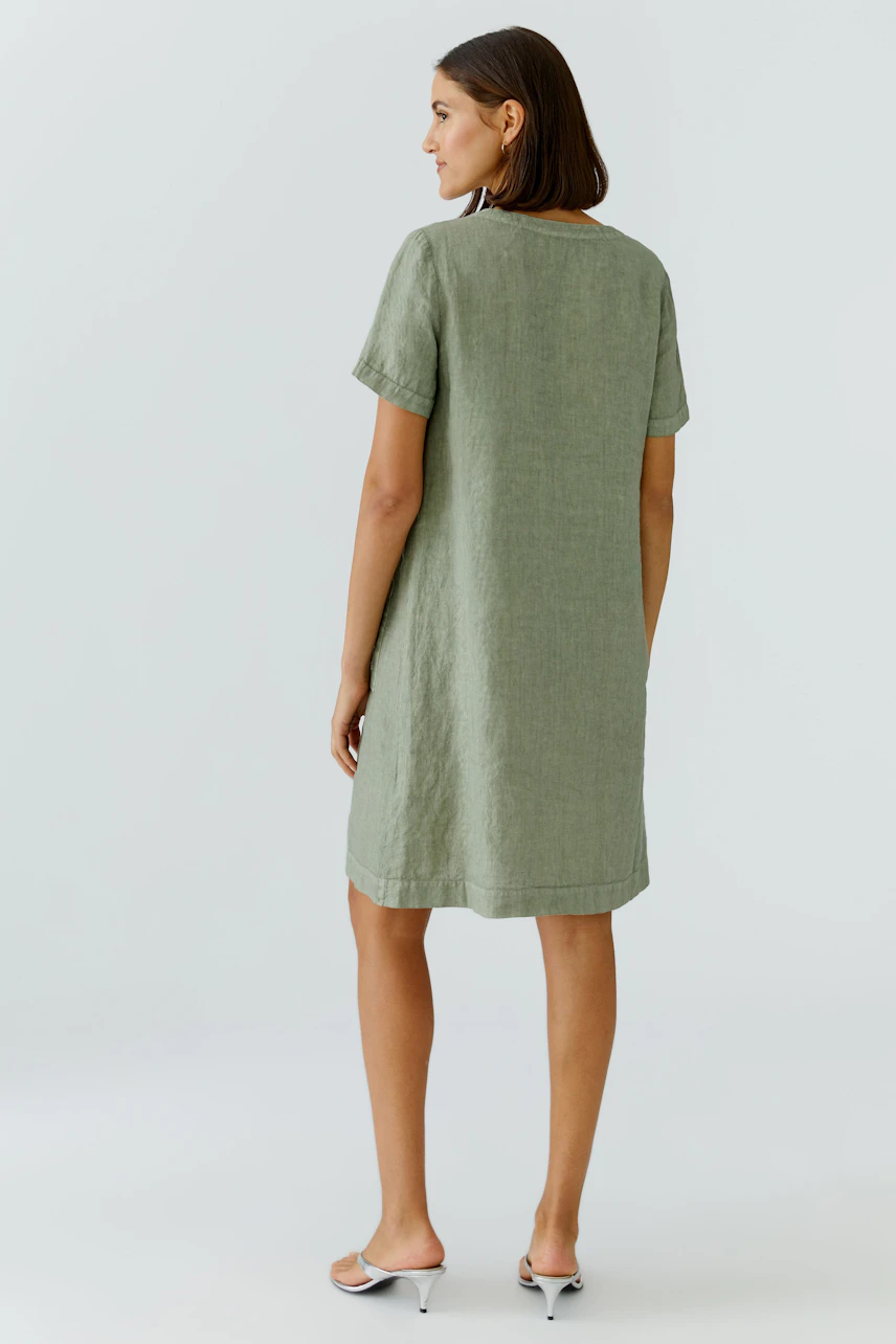 A-Linien-Kleid: Frau im lässigen, grünen Kleid aus Leinen, Rückansicht, schlicht und bequem.