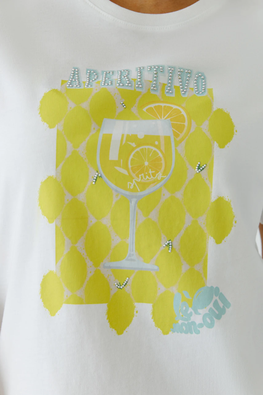 Weißes Damen-T-Shirt mit gelbem Aperitivo-Print und Zitrone. Frau trägt es lässig.