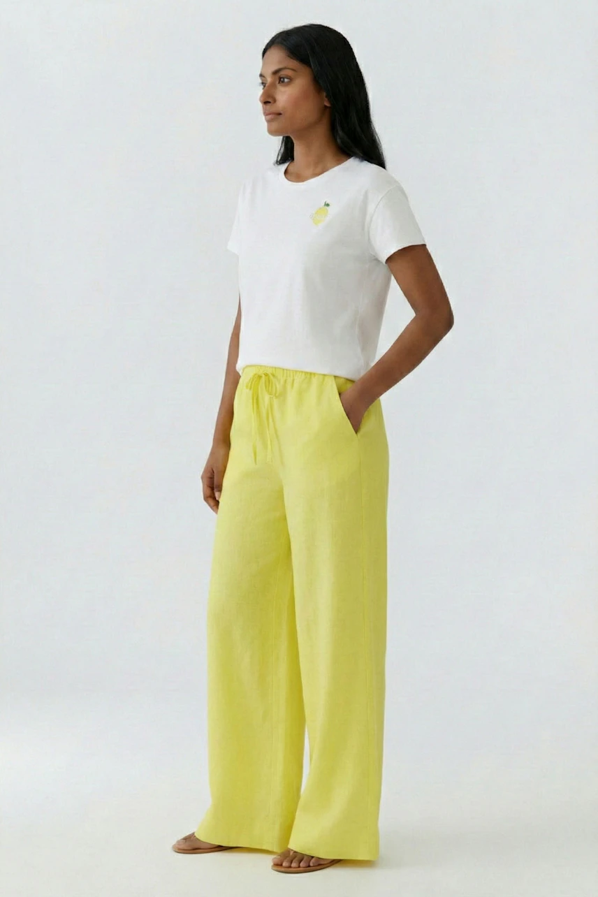 Weißes T-Shirt: Frau trägt ein schlichtes T-Shirt mit kleinem Motiv, kombiniert mit gelber Hose.