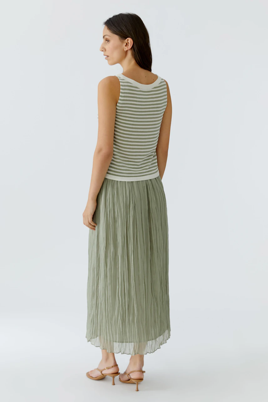 Gestreiftes Damen-Top: Frau im ärmellosen, gestreiften Top und langer, fließender Rock von hinten.