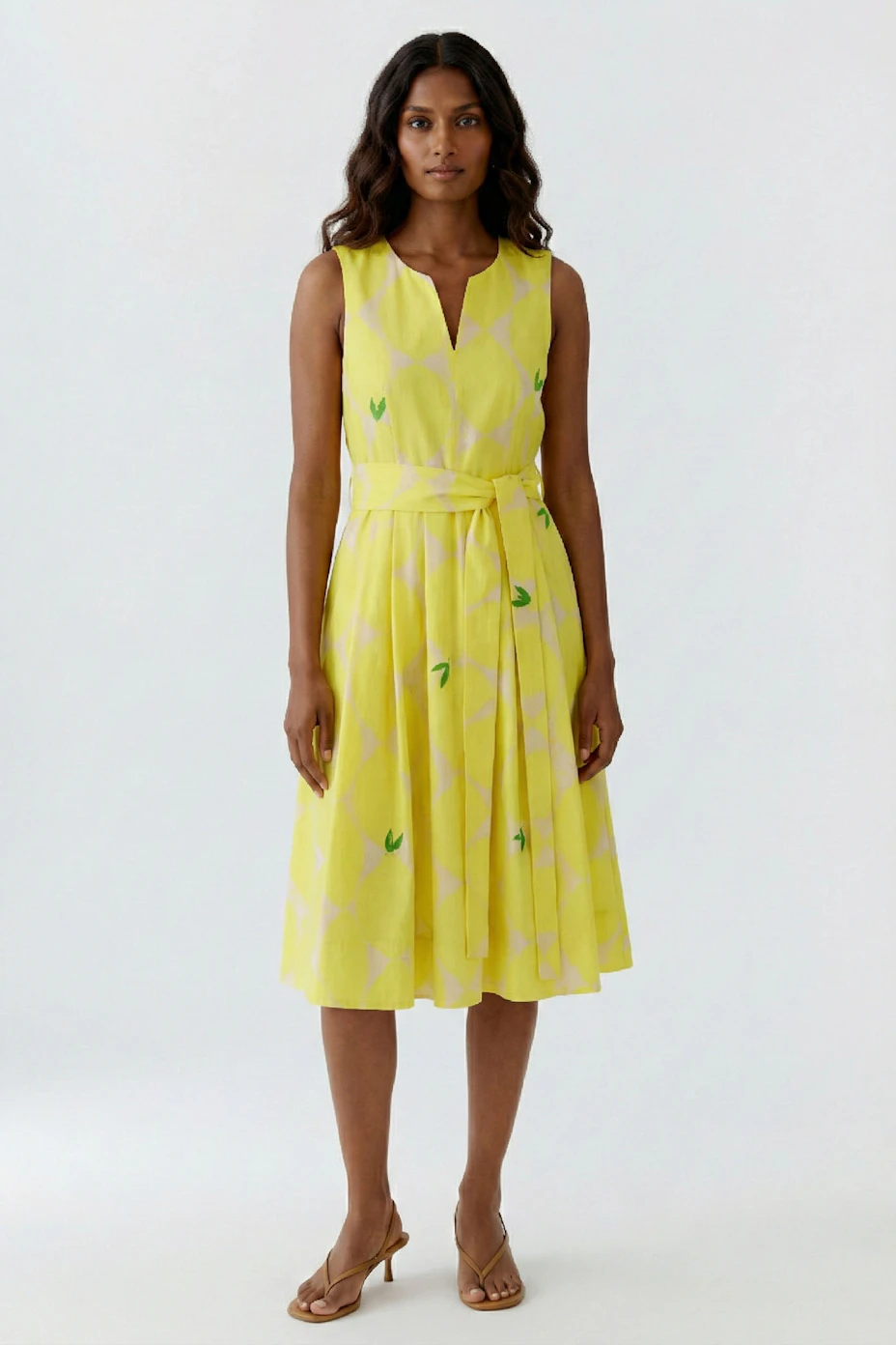 Vibrant yellow midi dress with geometric patterns, sleeveless design, and a matching waist tie.