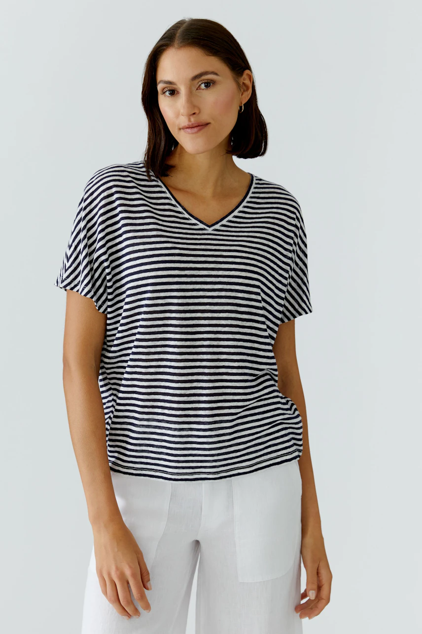 Casual T-shirt: Woman in a striped T-shirt with short sleeves and relaxed fit, paired with white pants.