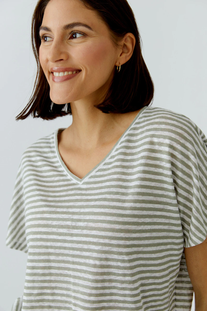 Casual women's T-shirt: Smiling woman in a striped T-shirt with short sleeves and a relaxed fit.
