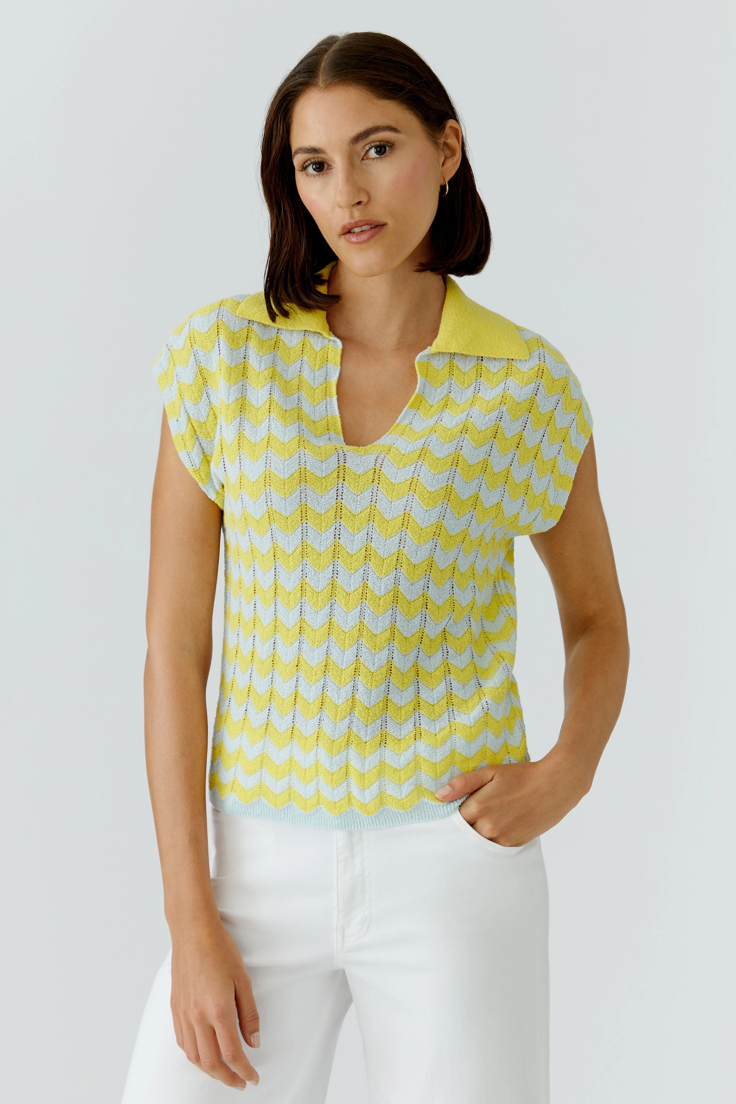 Casual women's pullover: Woman in yellow and white chevron pullover with short sleeves and open collar.