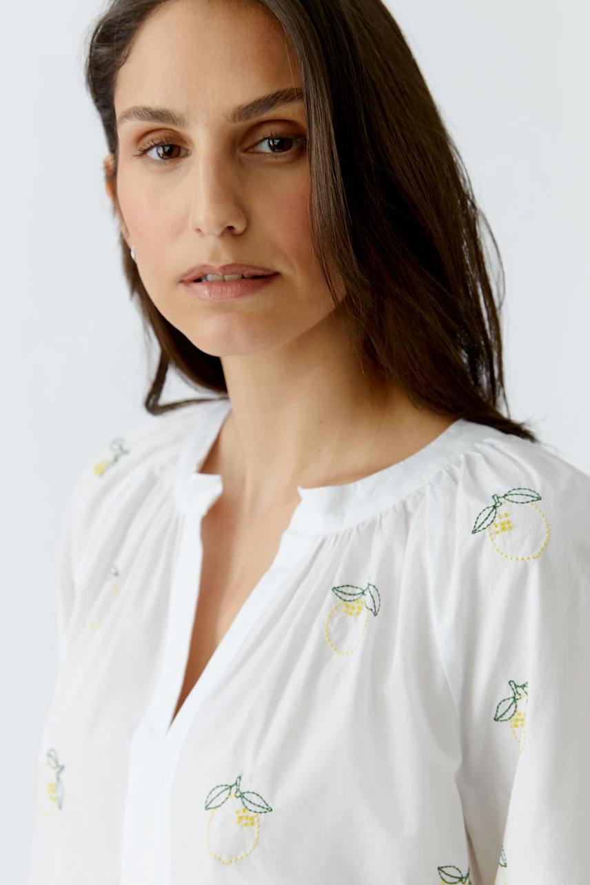 Weiße Tunika: Frau in weißer Tunika mit Zitronenstickerei, lässiger Look.