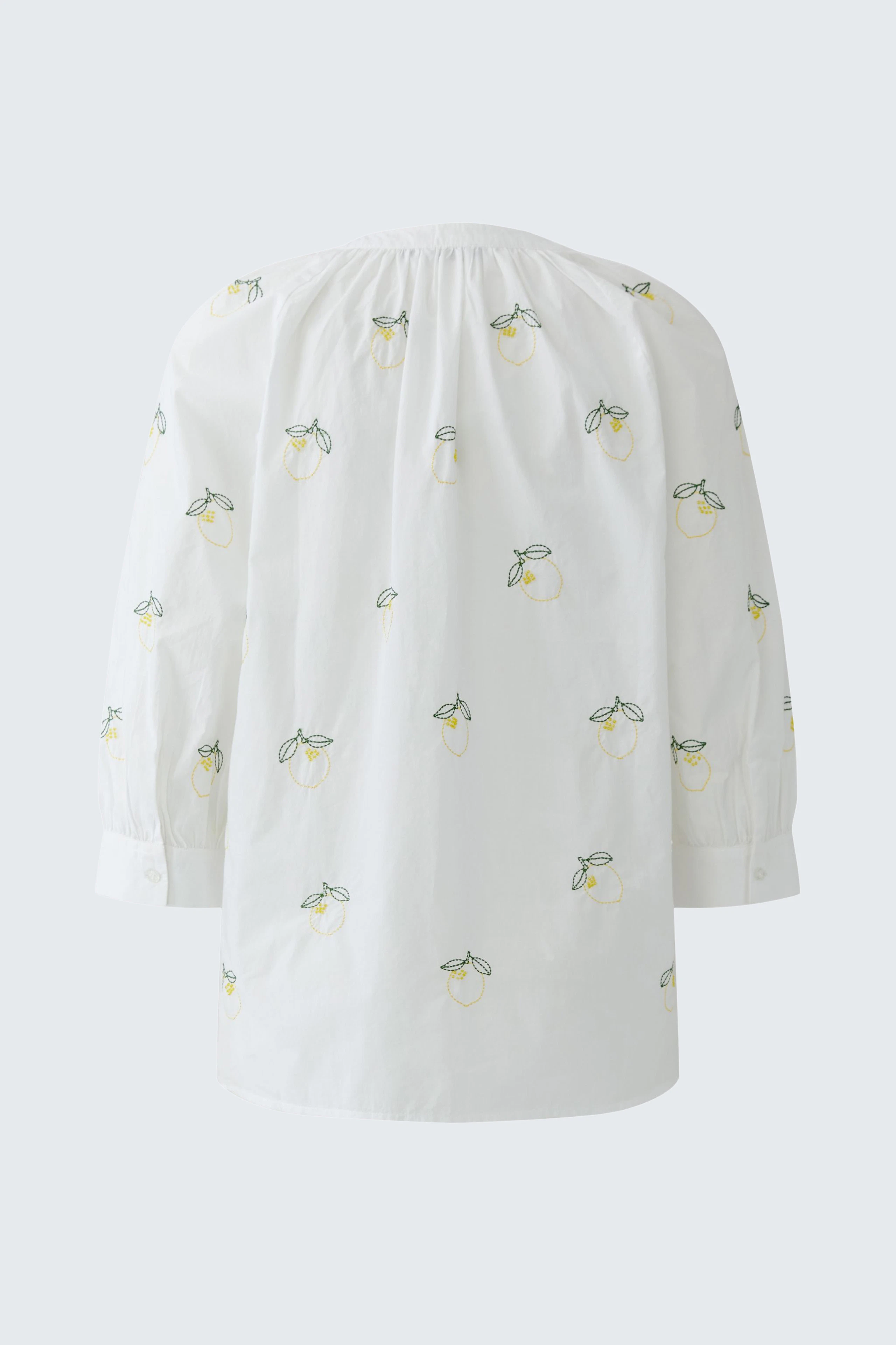 Weiße Tunika mit Zitronenmuster, locker geschnitten, ohne Model abgebildet.