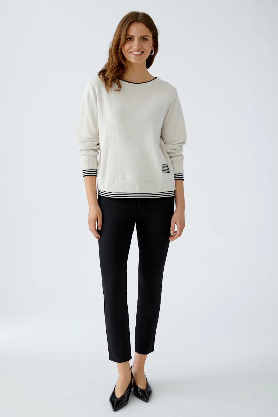 Bequemer Damen-Pullover in hellem Beige mit sportlichem Streifenmuster am Saum und Logo-Detail.