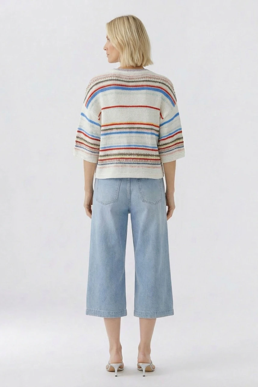Casual pullover: Woman in a striped pullover and light blue jeans, viewed from the back.