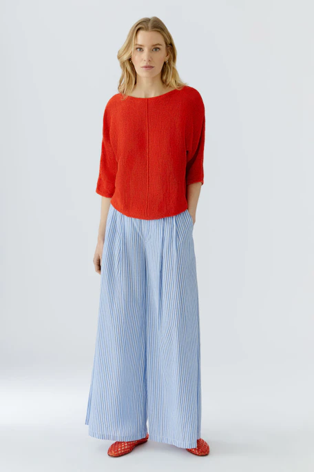 Bright red pullover with wide sleeves, perfect for a bold and casual look.