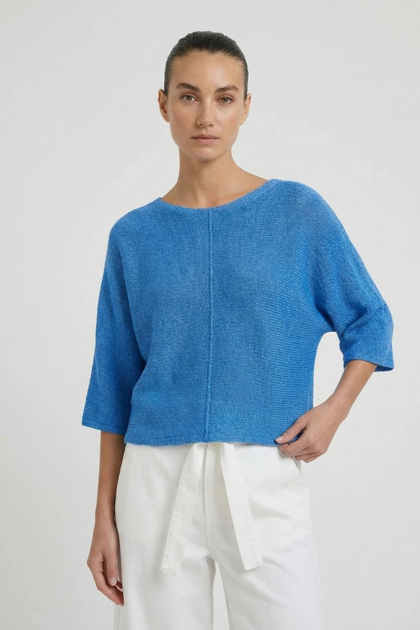 Lässiger Damen-Pullover: Frau im blauen Pullover mit Dreiviertelärmeln und weißer Hose schaut direkt.