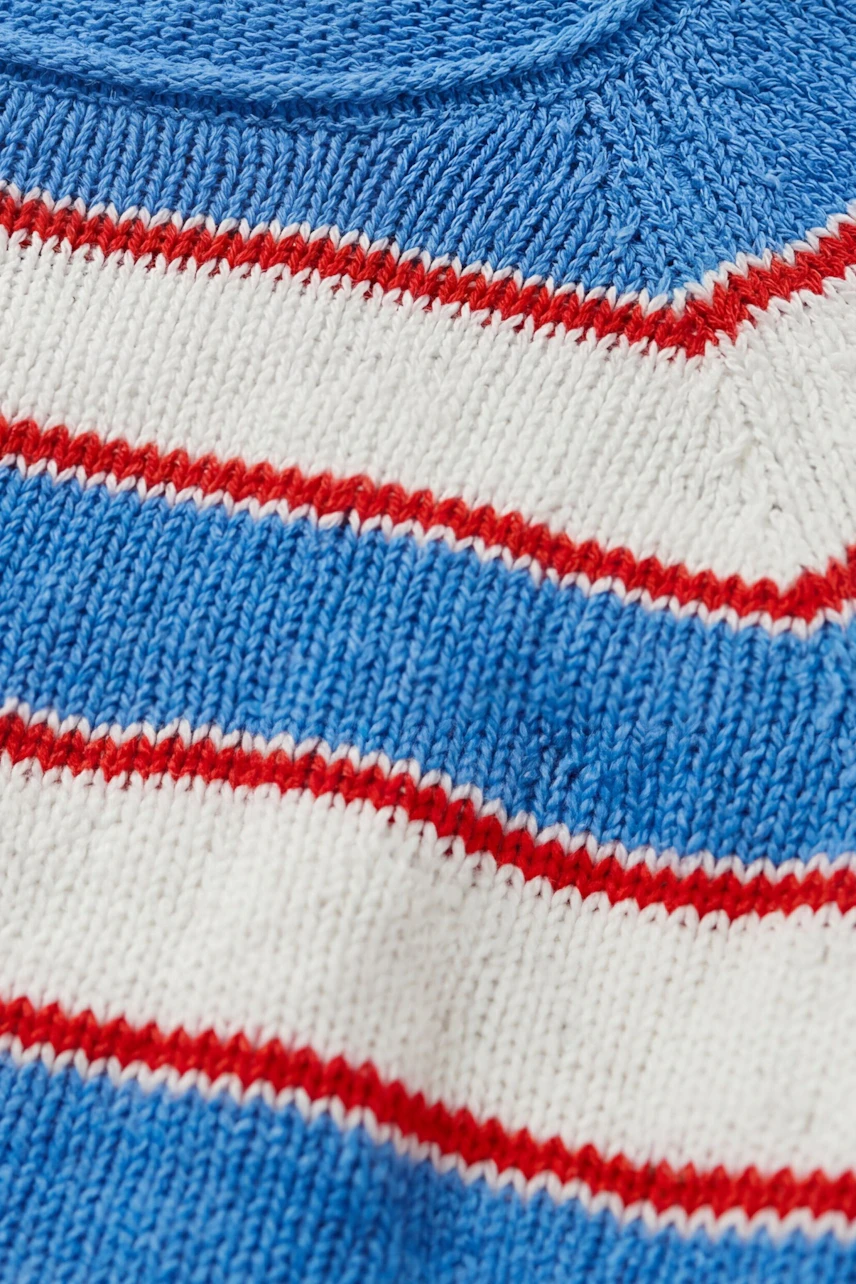 Striped pullover in blue, white, and red. No model, just the garment's close-up texture.