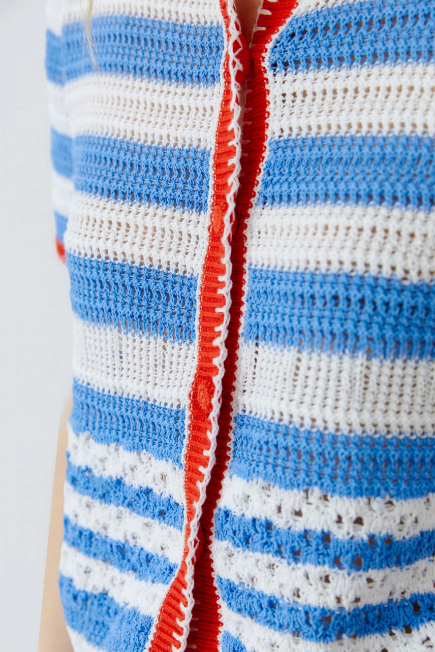 Striped cardigan: Woman in blue and white striped knit cardigan with red accents, casual and vibrant.