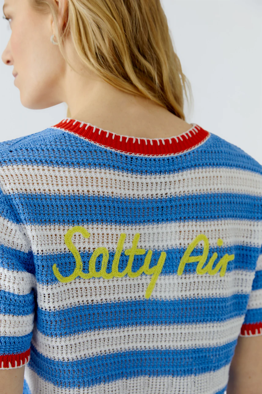 Striped cardigan: Woman in blue and white striped cardigan with 'Salty Air' text on the back.
