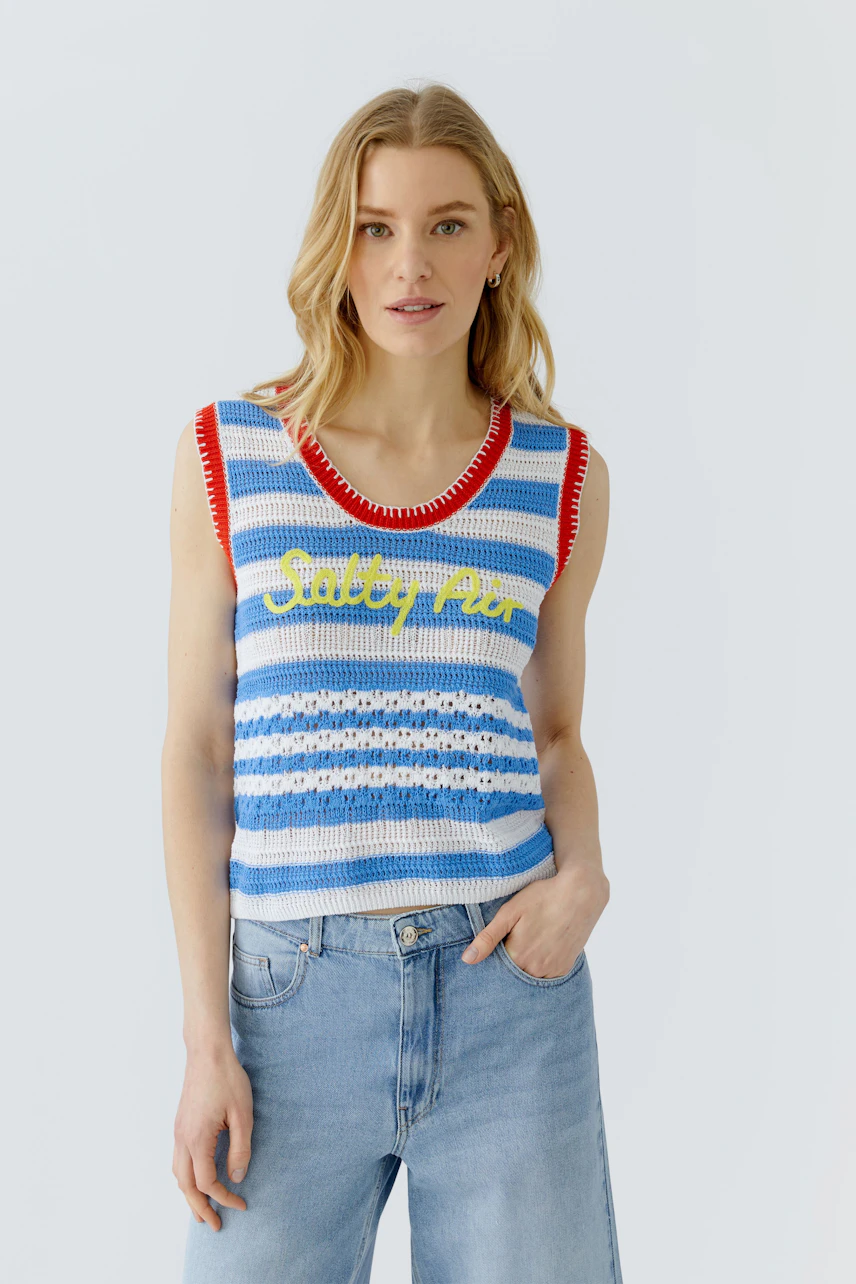 Casual women's top: Woman in a striped crochet top with 'Salty Air' text, paired with relaxed jeans.