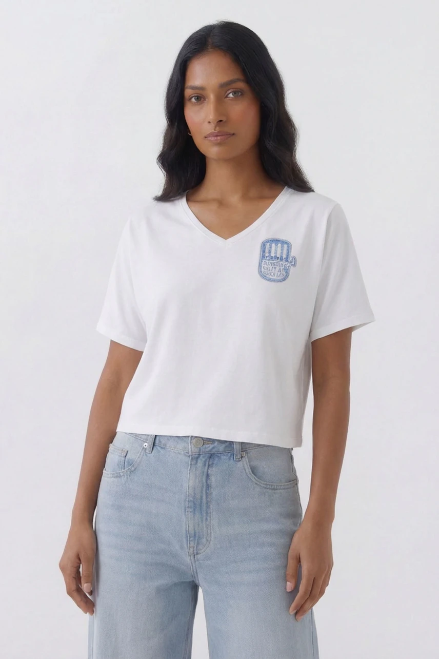Casual women's T-shirt: Woman in white V-neck T-shirt with blue graphic, paired with light jeans.