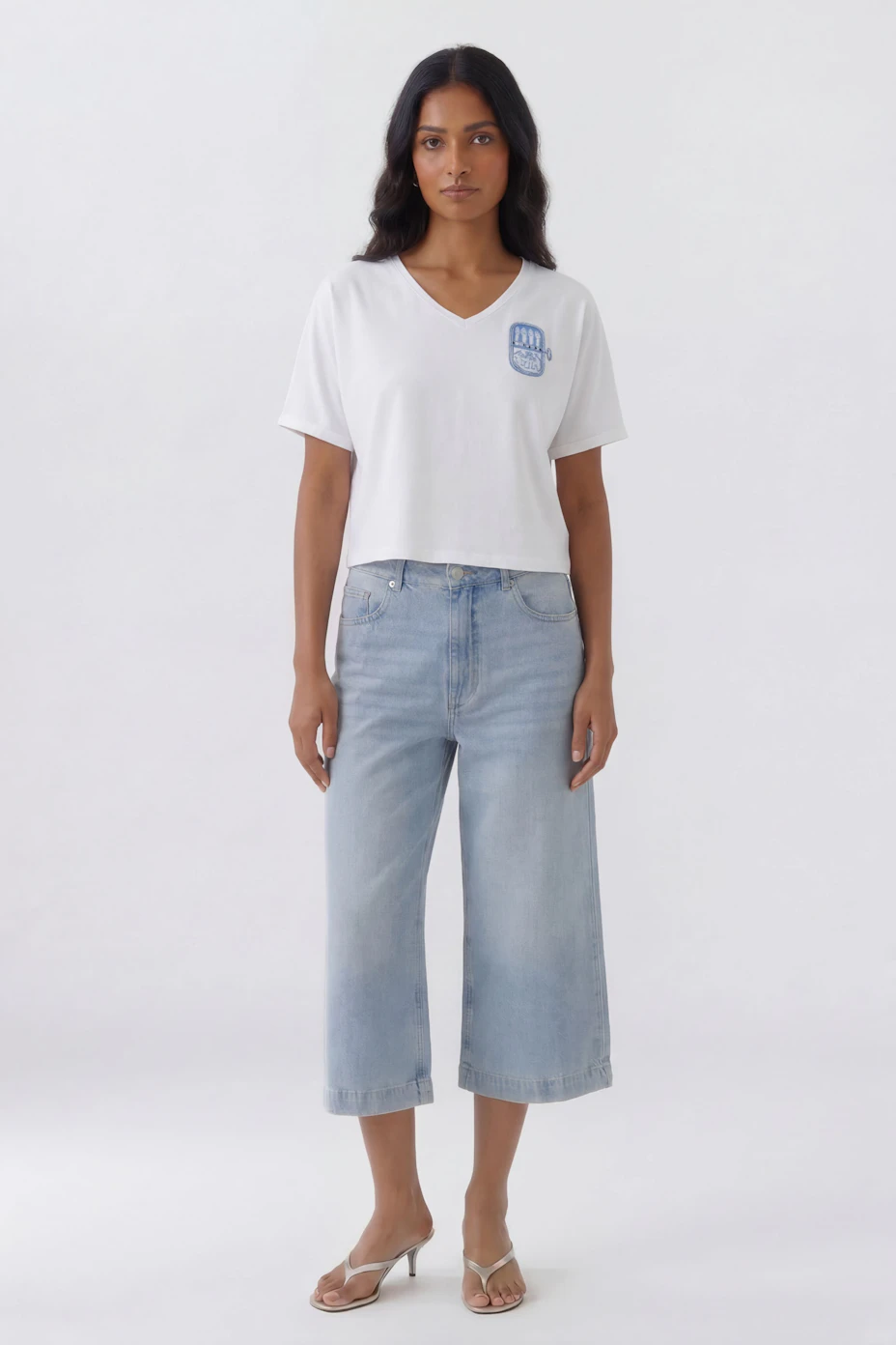 Casual women's T-shirt: White V-neck with blue graphic on chest, short sleeves, relaxed fit.