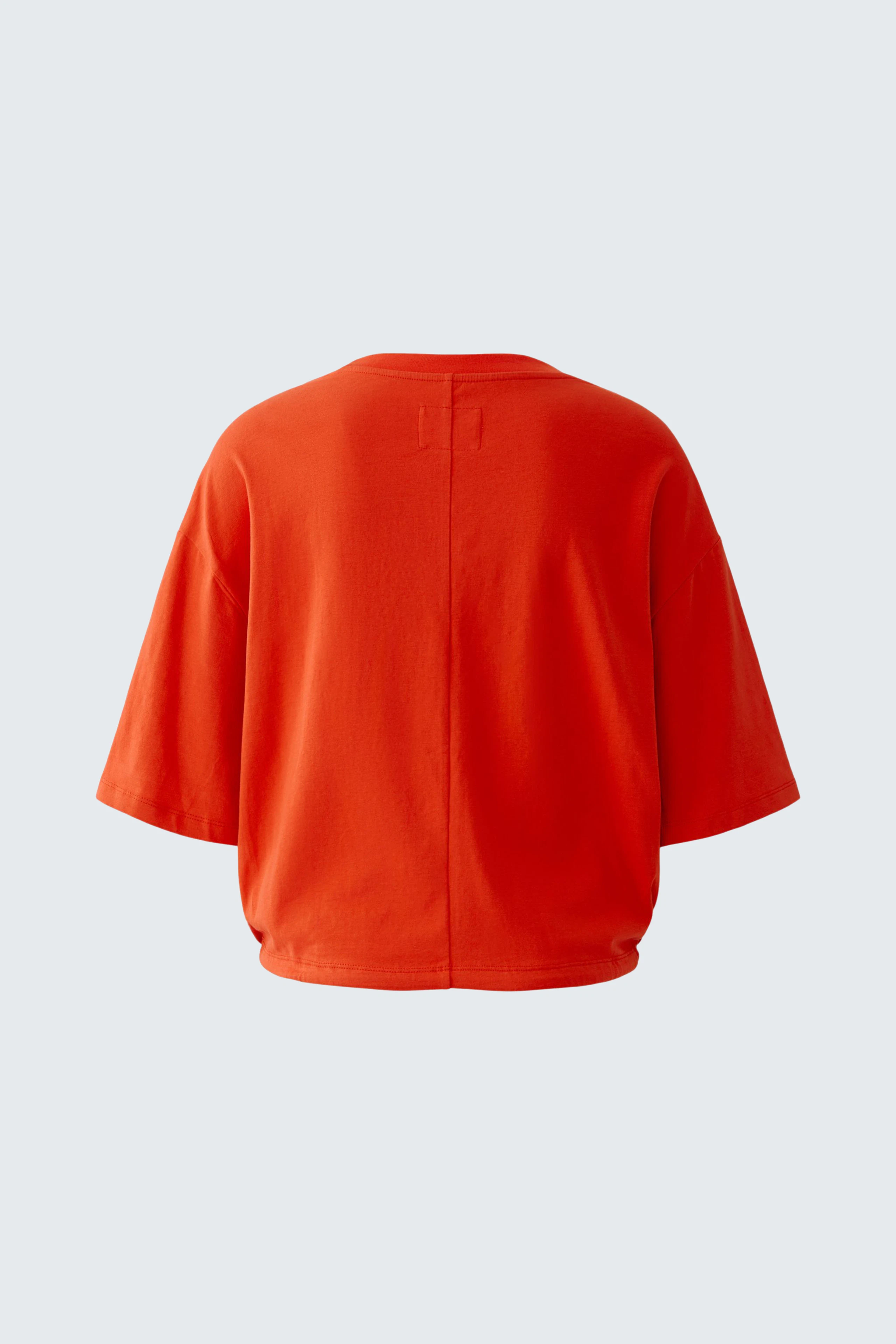 Bright orange T-shirt with wide sleeves, shown from the back. Casual and vibrant design.