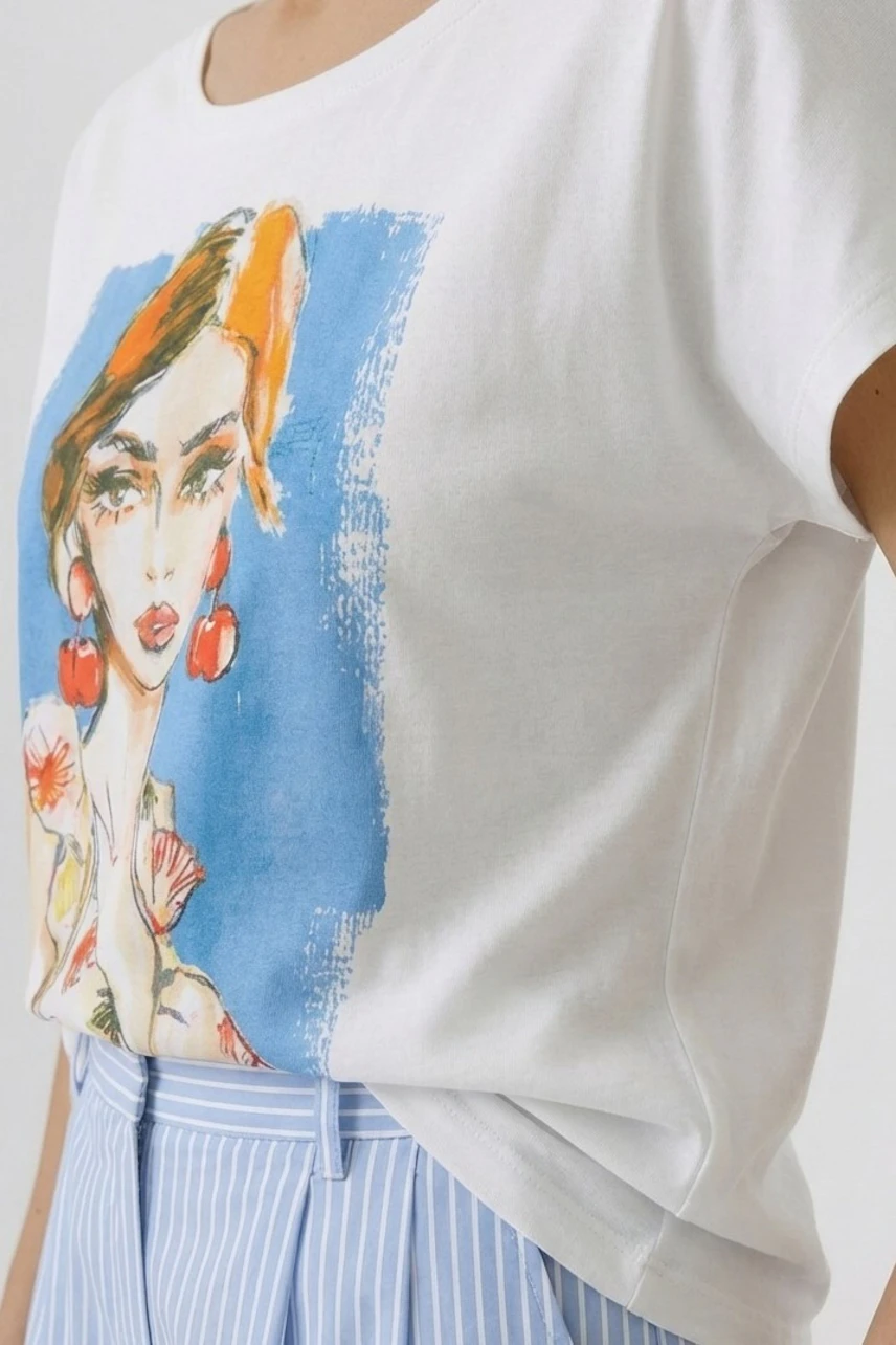 Casual T-shirt: Woman in white T-shirt with colorful print, paired with blue striped pants.
