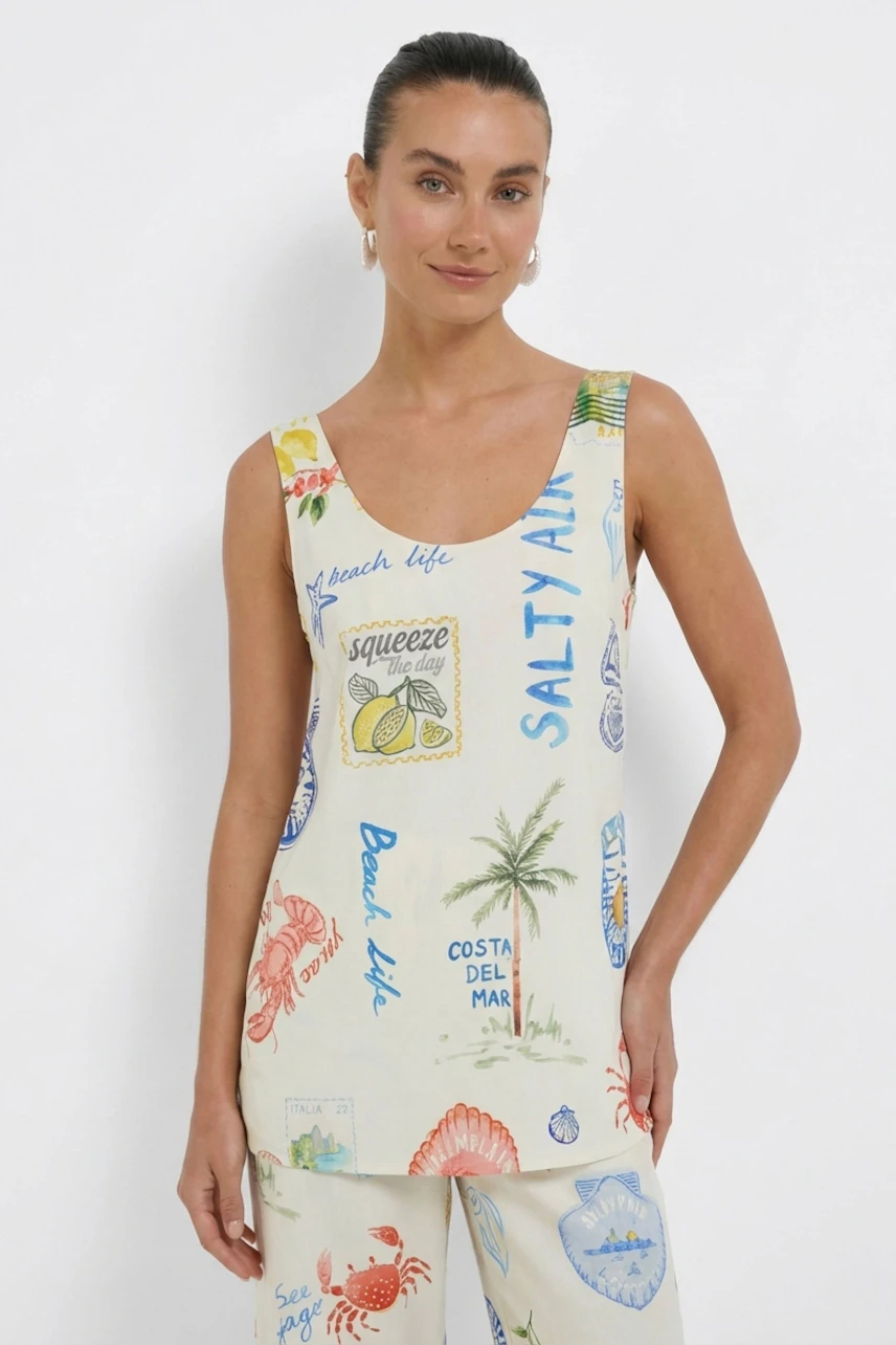 Casual women's top: Woman in a printed sleeveless top with beach-themed graphics, standing confidently.