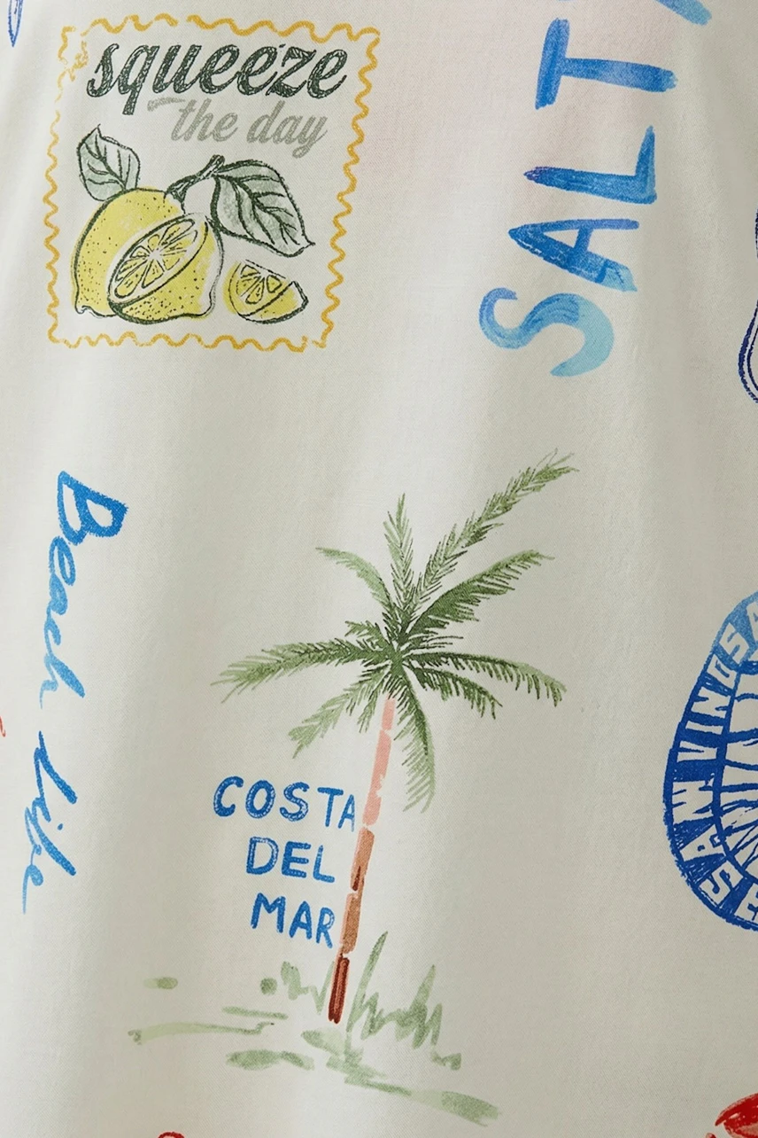 Casual women's top with beach-themed prints, featuring palm trees and lemons.