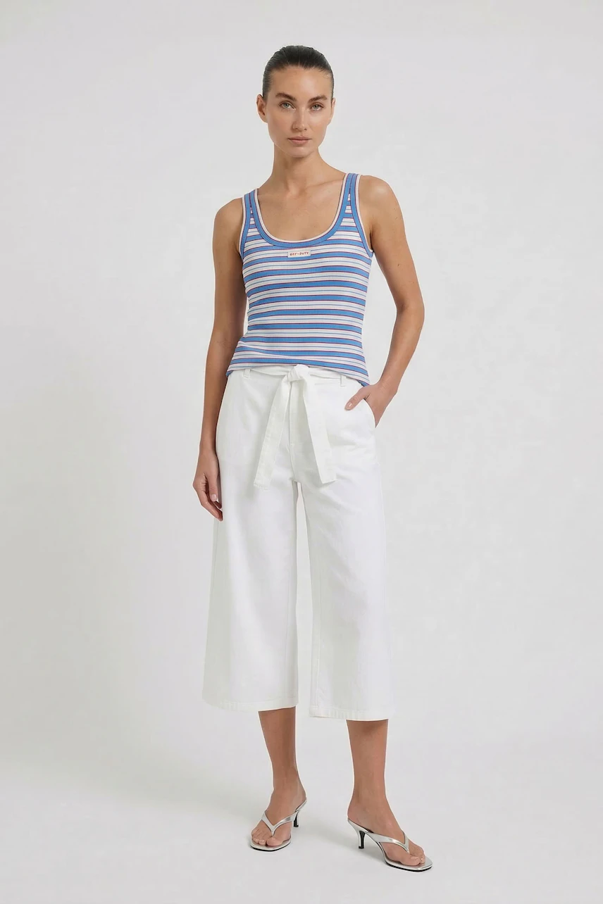 Striped tank top: Woman in blue and white striped tank top with white culottes and sandals.
