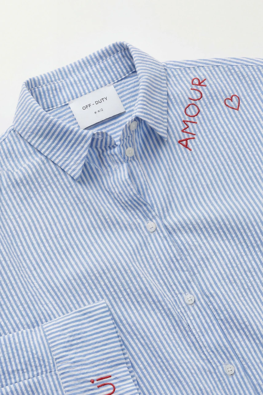 Striped blouse with "Amour" embroidery, blue and white, button-up style, casual and chic.