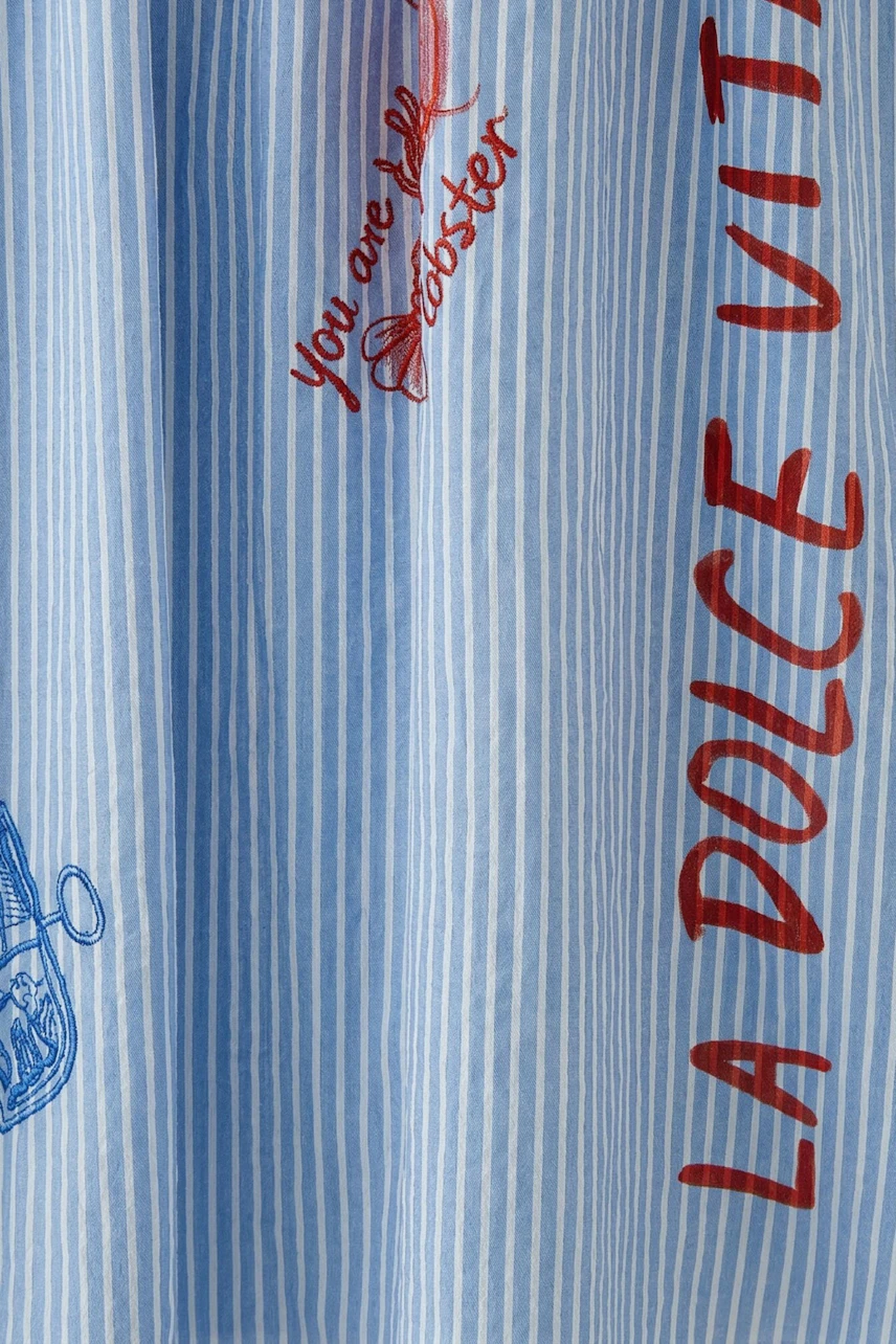 Striped A-line skirt with red and blue prints, featuring playful text and motifs. Casual and stylish.