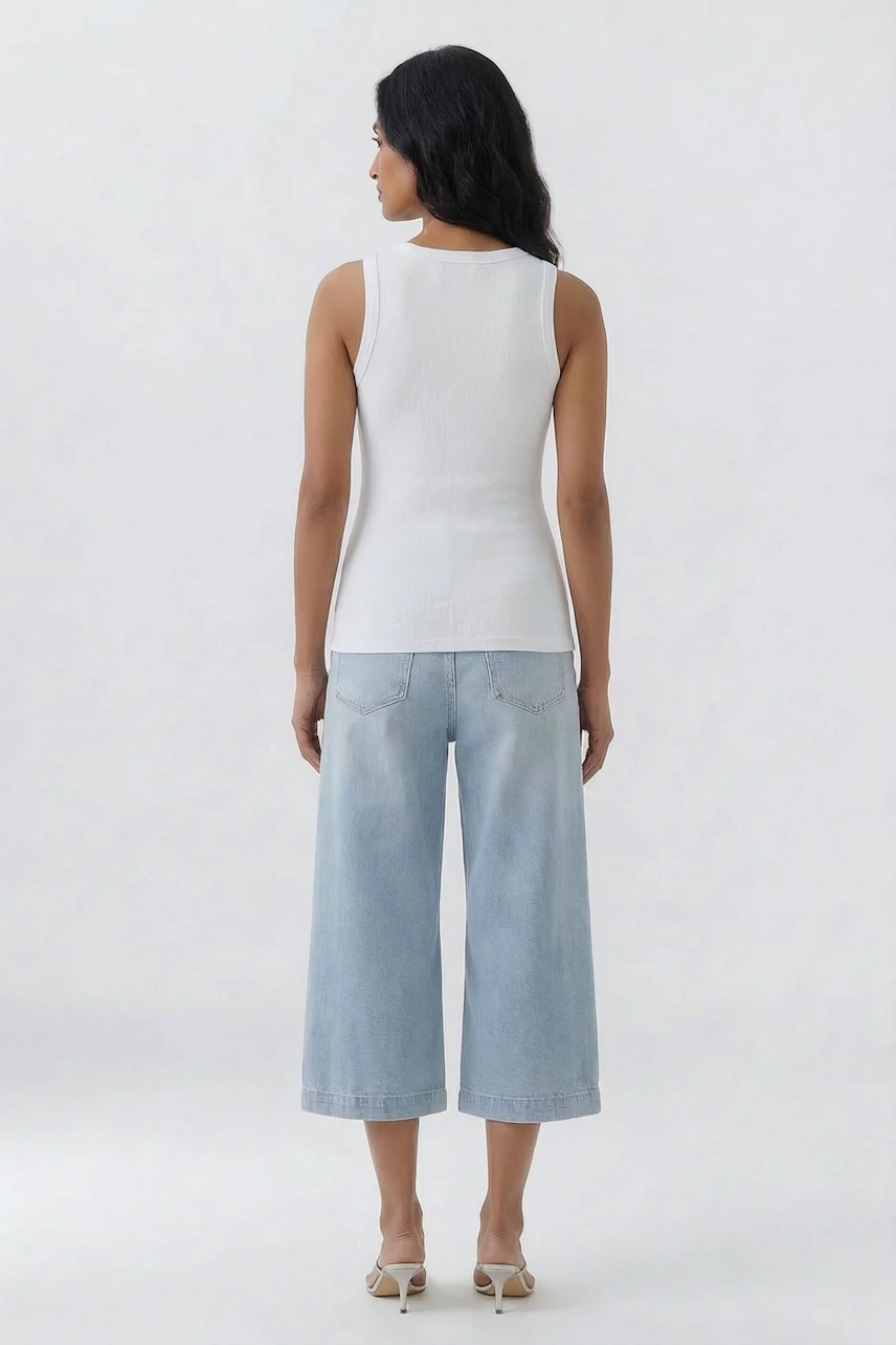 Casual tank top: Woman in white tank top and light blue jeans, viewed from the back.