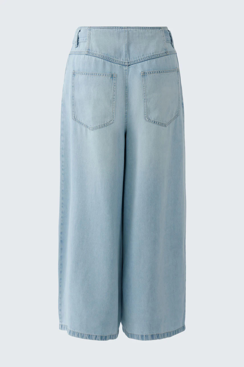 Casual denim culotte: Light blue wide-leg pants with back pockets, perfect for a relaxed look.
