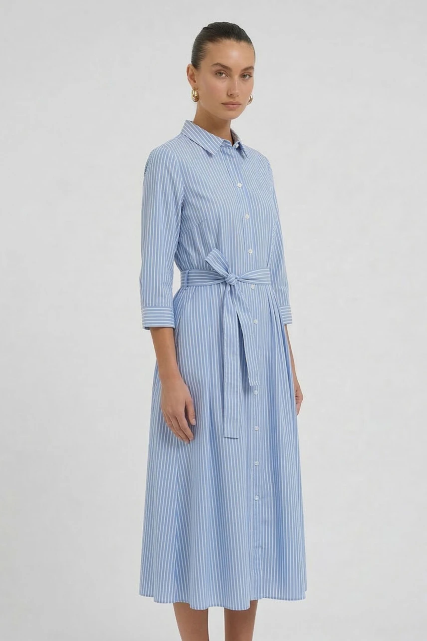 Striped midi dress: Woman in blue and white striped dress with button front and waist tie, standing confidently.
