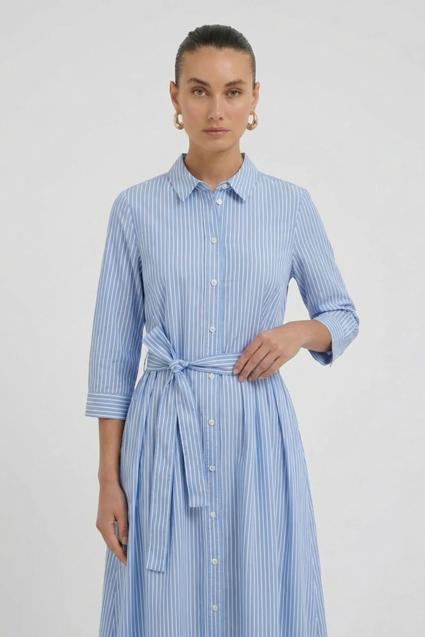 Casual midi dress: Woman in a blue striped shirt dress with a waist tie, looking relaxed.