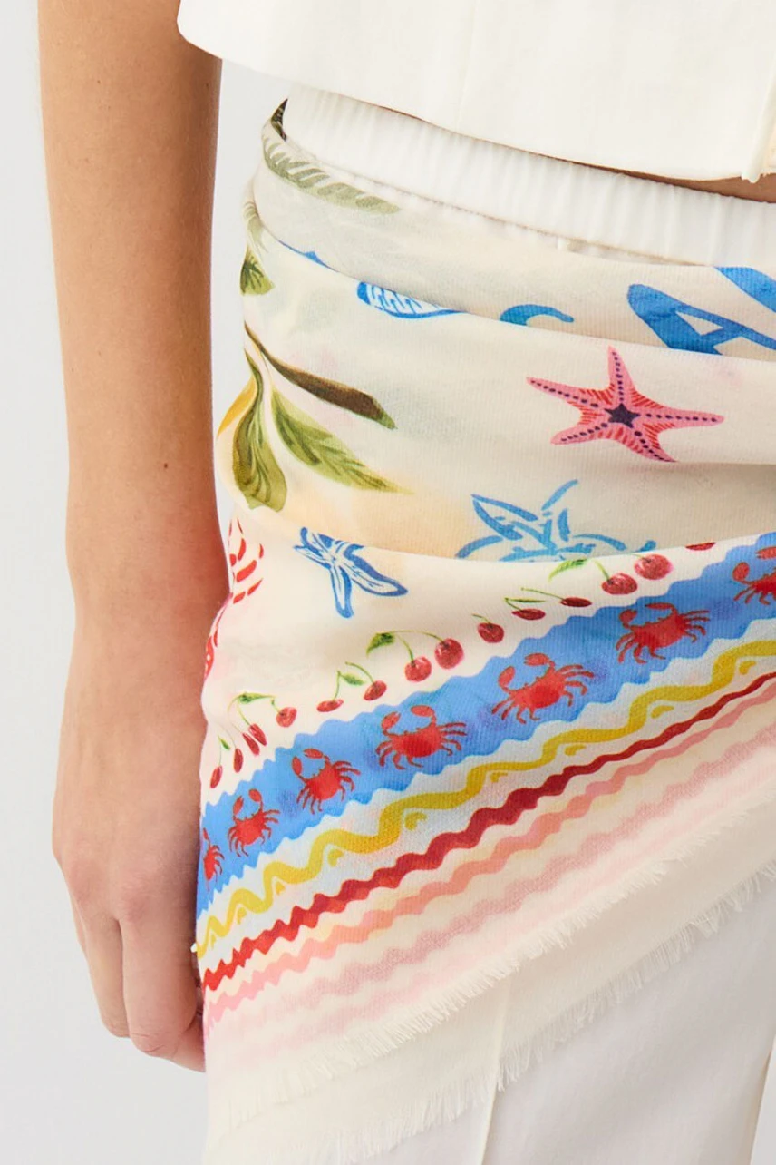 Colorful scarf: Woman wearing a vibrant scarf with sea-themed patterns, adding a playful touch.