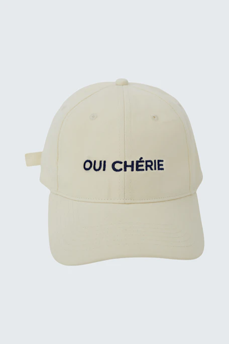 Casual women's cap in cream with 'OUI CHÉRIE' embroidered in navy.