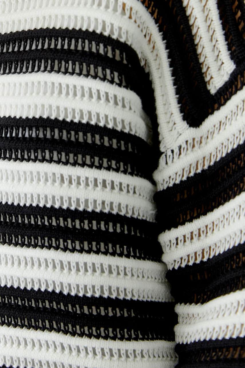 Striped pullover: Close-up of black and white knit pattern, showcasing texture and style.