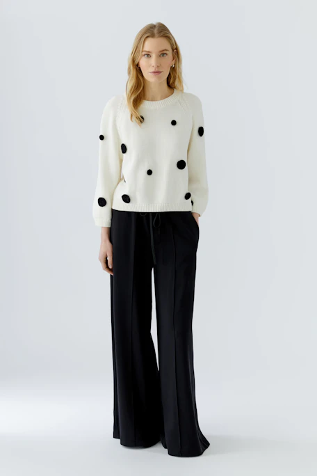 Weißer Damen-Pullover mit schwarzen Punkten, lässig und modern. Ideal für einen stilvollen Freizeitlook.