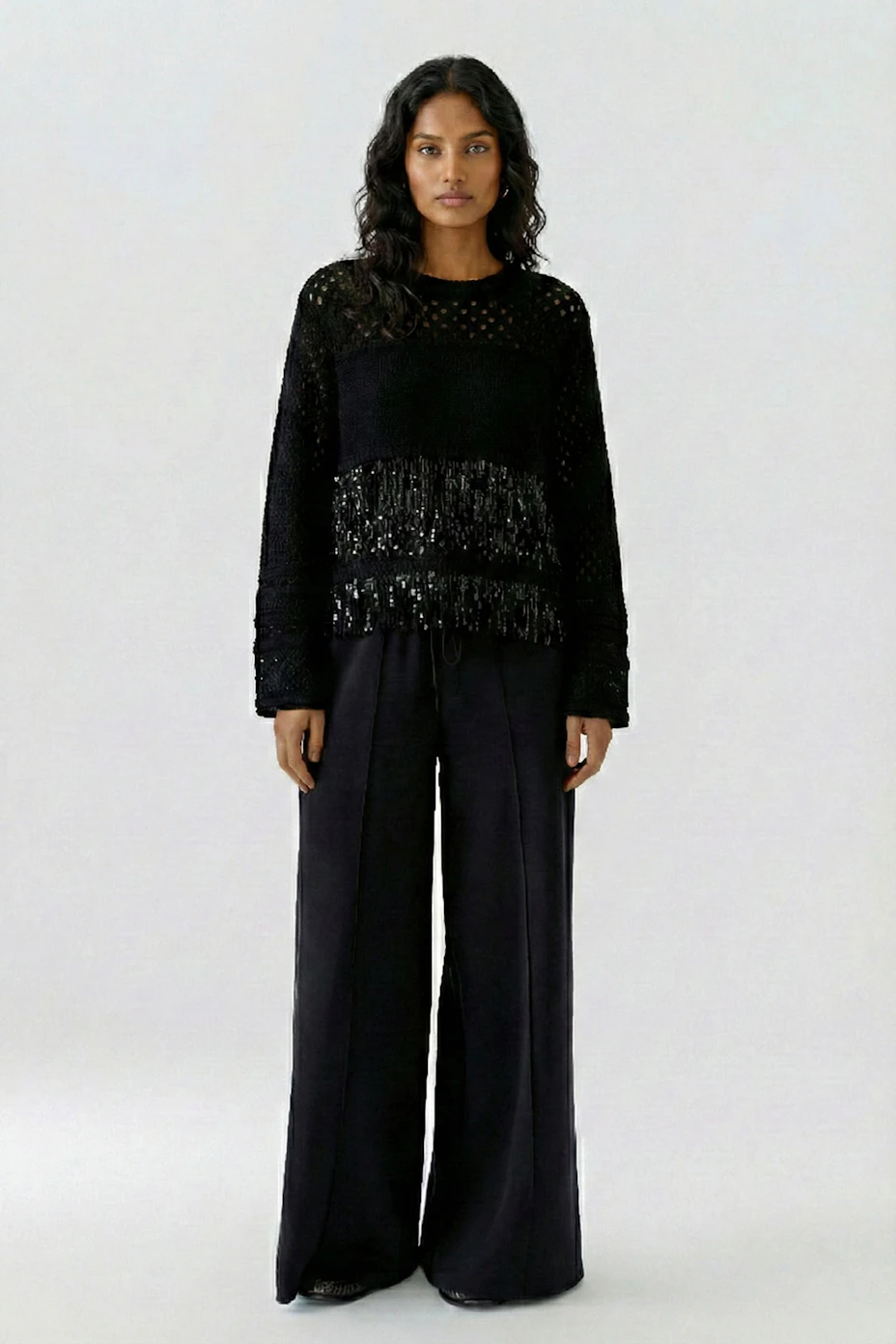 Black pullover with textured knit and fringe details, perfect for a stylish, casual look.