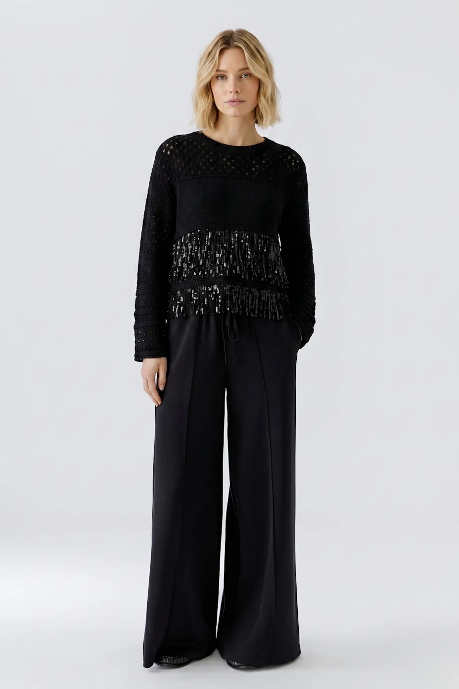 Schwarzer Damen-Pullover: Strickdesign mit transparenten Details und Fransen für einen modernen Look.