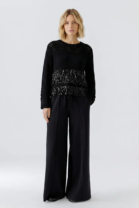 Schwarzer Damen-Pullover: Strickdesign mit transparenten Details und Fransen für einen modernen Look.