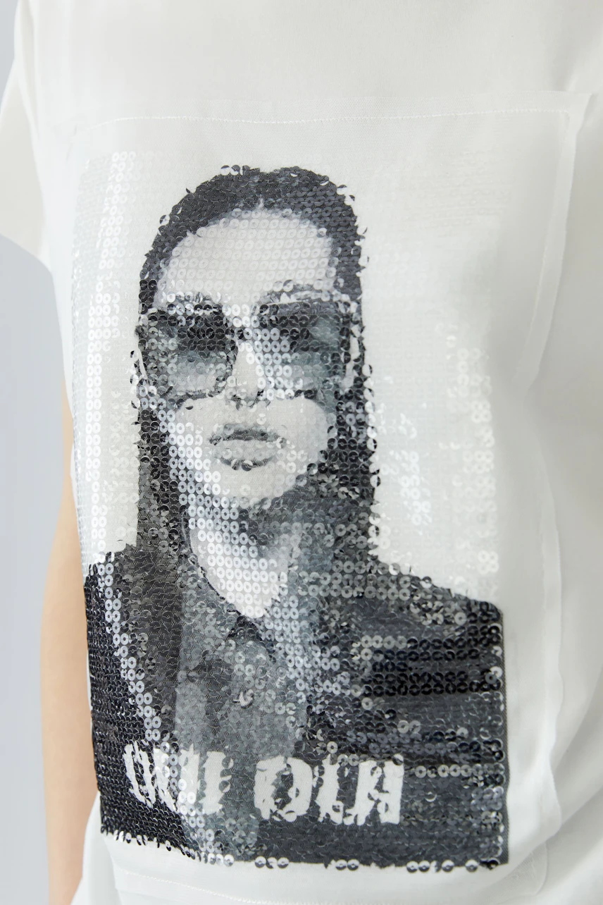 White T-shirt with sequin graphic of a woman in sunglasses, adding a trendy touch to casual wear.