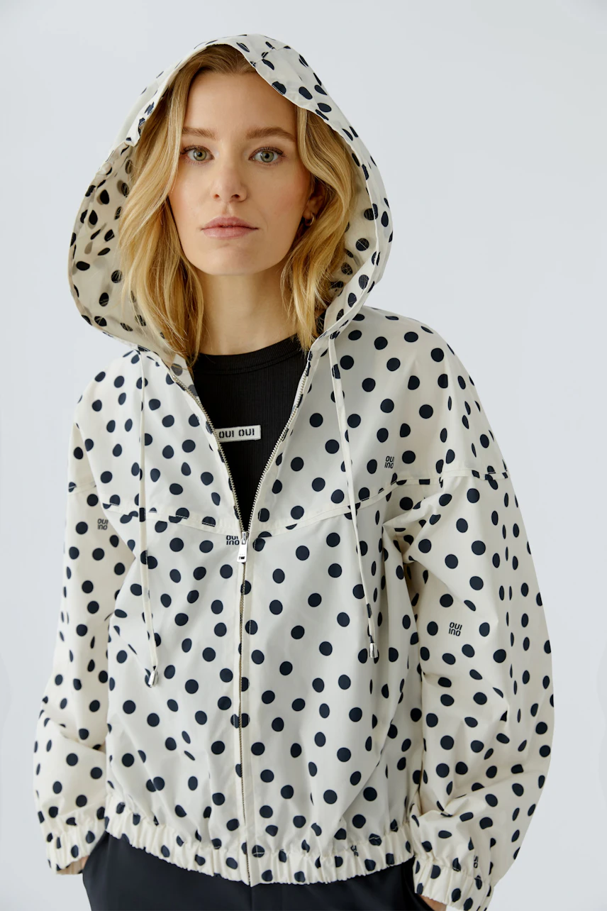 Damen-Blouson: Frau im gepunkteten Blouson mit Kapuze, lässig und modern.