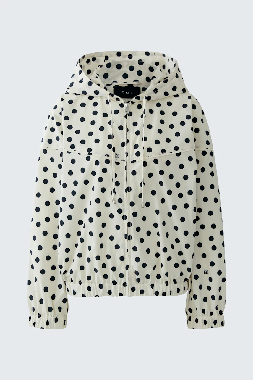 Gepunkteter Blouson: Weißer Blouson mit schwarzen Punkten, Kapuze und elastischem Bund, ohne Model.